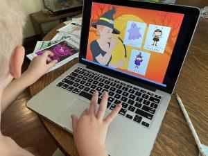 child at laptop playing sign language halloween game online sign language Halloween 