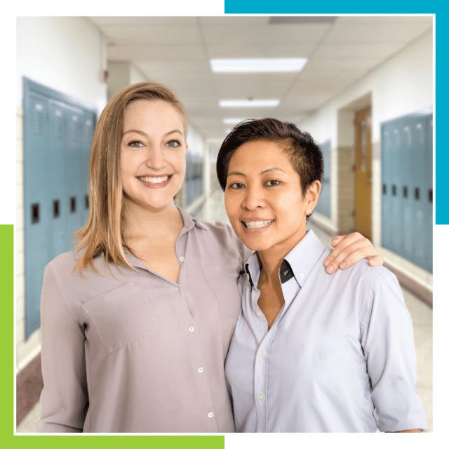 Two professional ASL interpreters smiling in a school hallway.