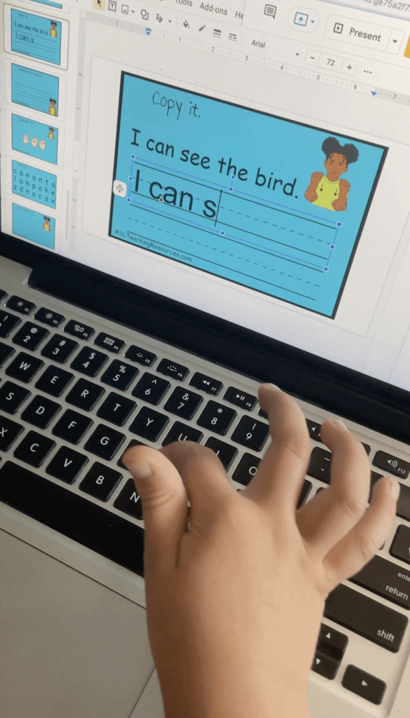 child's hand on computer playing sight word game