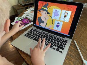 child at laptop playing sign language halloween game online